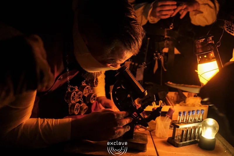 Appunti al banco alchemico alla luce di una lanterna, Exclave settembre 2026