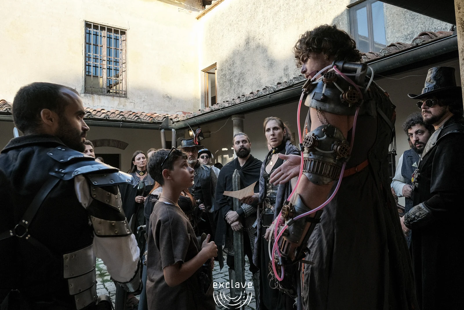 Personaggi riuniti nel cortile del Convento dell’Incontro, Exclave settembre 2026