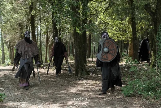 Personaggi mascherati con spade e scudi nel bosco, Exclave settembre 2026